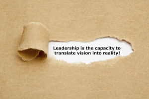 The quote Leadership is the capacity to translate vision into reality, appearing behind torn brown paper.
